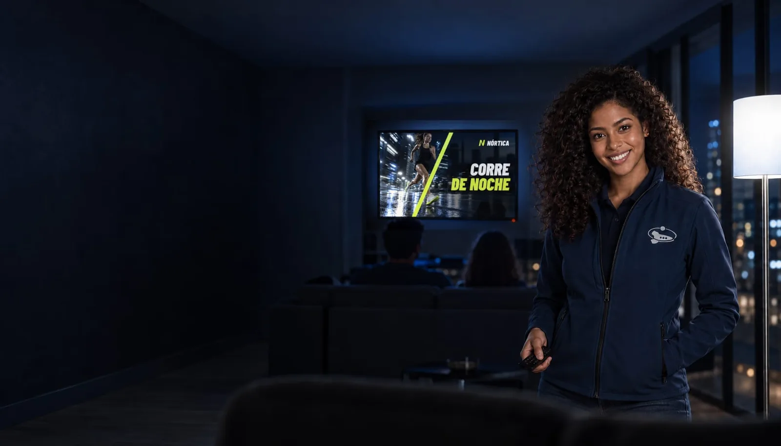 Un living de noche con la TV conectada mostrando el anuncio de la marca de ejemplo