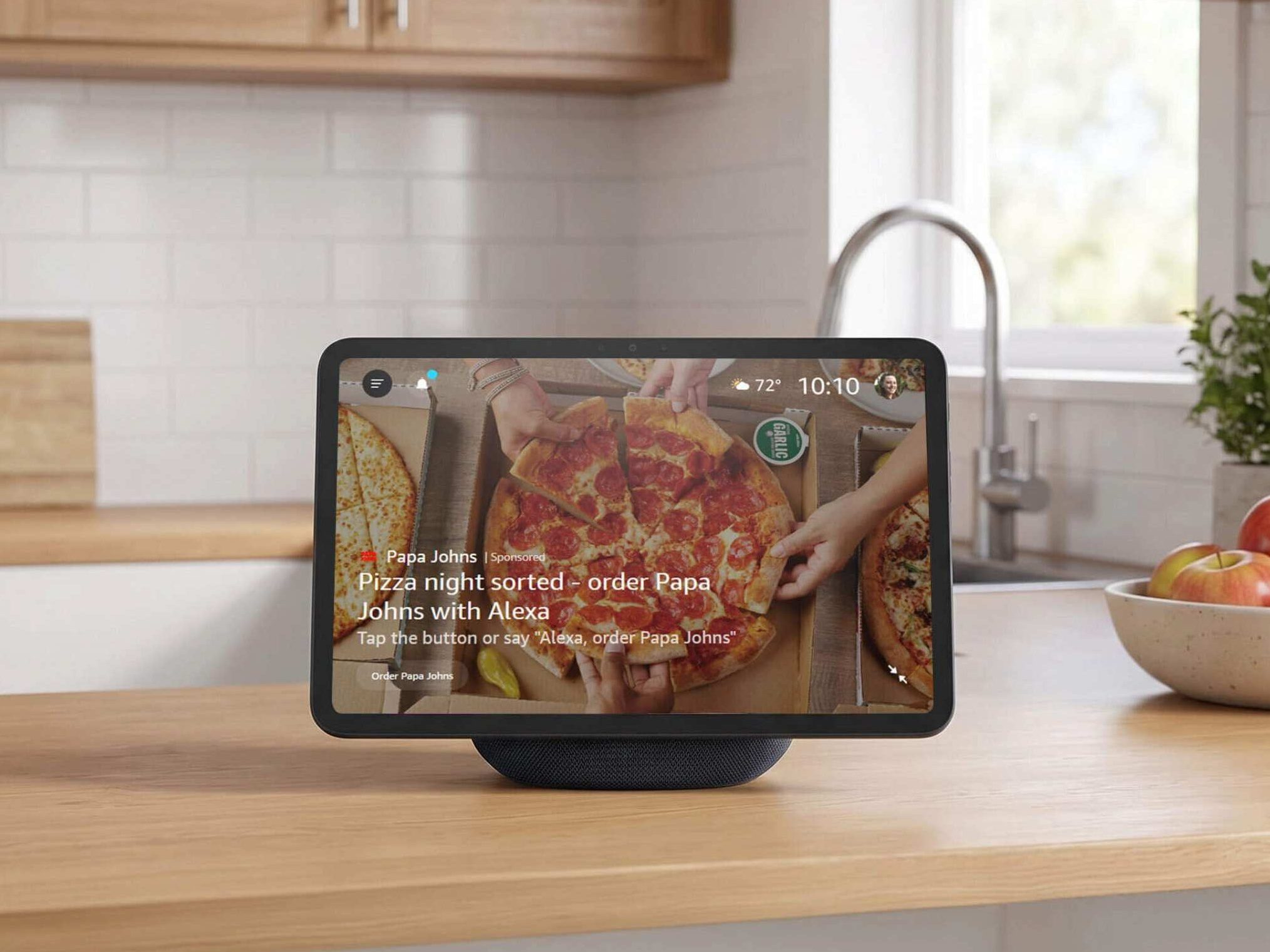 Pantalla inteligente de Amazon Alexa sobre una encimera de cocina mostrando un anuncio patrocinado de Papa Johns